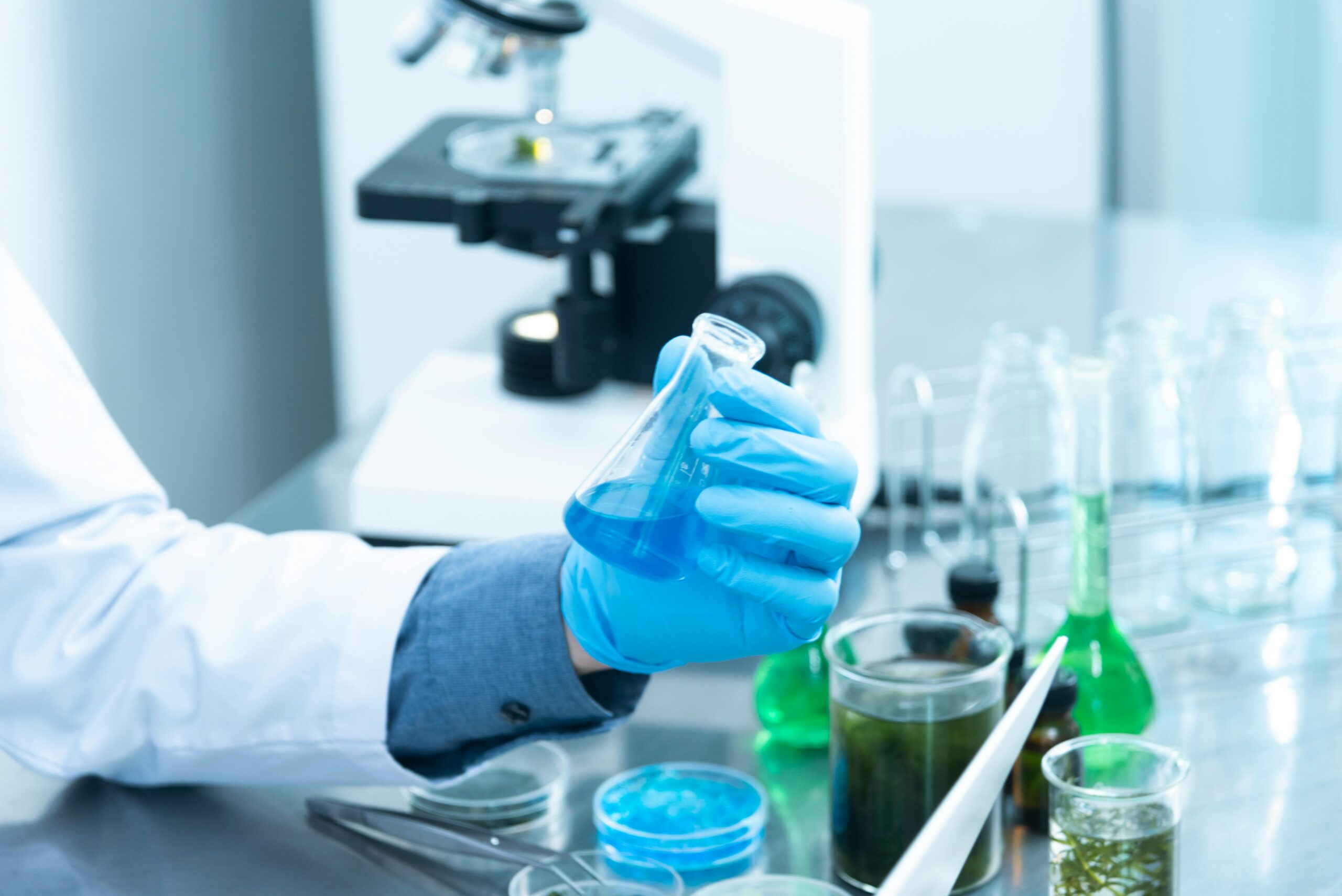 Chemist holding a vial of liquid, representing innovative uses of bacteria in industry and agriculture.